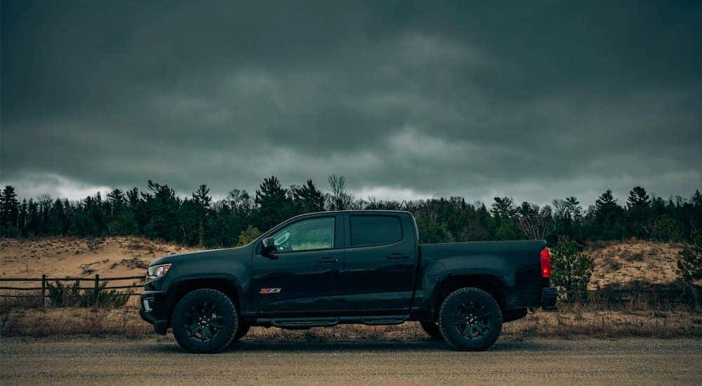 A black 2018 Chevy Colorado Z71 is shown from the side under a stormy sky.
