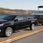 A black 2021 Chevy Colorado is shown towing a boat.