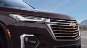 A close up shows the grille and passenger side headlight on a purple 2022 Chevy Traverse High Country.