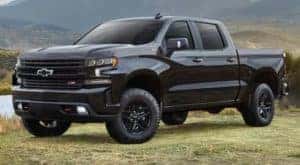 A black 2022 Chevy Silverado 1500 Z71 Trail Boss is shown from the front at an angle after leaving a dealer that has a Chevy Silverado for sale.
