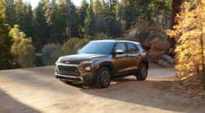 A blue 2022 Chevy Trailblazer for sale is shown driving on a dirt road.