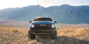 A 2024 Chevrolet Silverado parked on the rocks with the mountains in the background