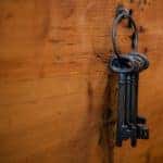 3 large iron keys hanging from a wall