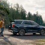Man walking toward 2023 Hyundai Palisade in Blue