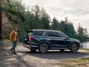 Man walking toward 2023 Hyundai Palisade in Blue