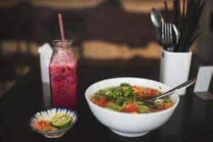 A bowl of soup and red juice on a table at a vegan restaurant in auburn, AL