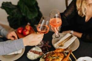 Man and Woman drinking wine while being served dinner