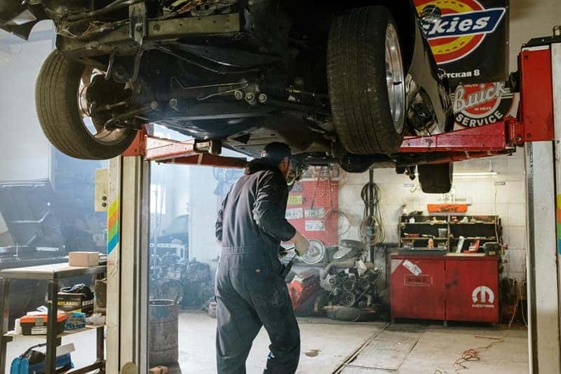 Man inspecting car in mechanic shop