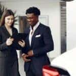 Car Dealer and Client Looking at a Document
