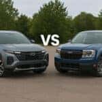 A high-resolution daytime photograph comparing two compact pickup trucks side by side on a paved surface, with a backdrop of green trees. On the left is a metallic gray 2025 Hyundai Santa Cruz with sleek, modern headlights and a bold front grille. On the right is a deep blue 2025 Ford Maverick, featuring a boxier front design and a traditional truck stance. Both vehicles have black trim accents and roof rails, with a white “VS” in bold letters centered between them. The lighting is soft and diffused, highlighting the contours and finishes of each truck.