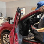 Danny recalibrating a windshield on a red Toyota Highlander