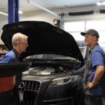 two Volkswagen service technicians checking engine oil