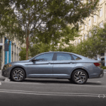 2023 Volkswagen Jetta drivers side view in gray parked in front of a tree