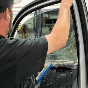 Kalispell Volkswagen Technician installing window tint