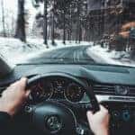 VW Steering wheel view driving Volkswagen down a snowy road