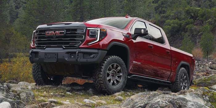 red GMC Sierra 1500 driving up on rocks