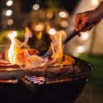 grilling with meat and flames outside at night