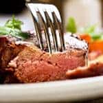 Tender and juicy, a fork pierces grilled beef fillet