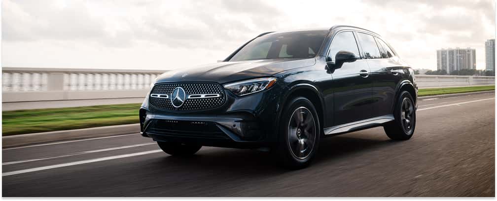 Front three-quarter view of a black 2026 Mercedes-Benz GLC SUV driving on an asphalt road.