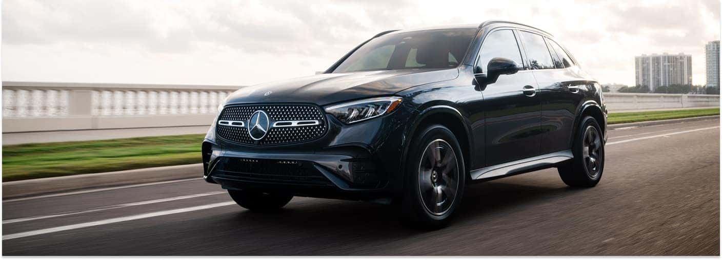 Front three-quarter view of a black 2026 Mercedes-Benz GLC SUV driving on an asphalt road.