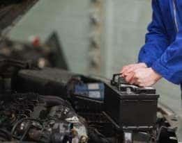 Technician installing new car battery