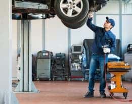 Service technician working on vehicle on lift