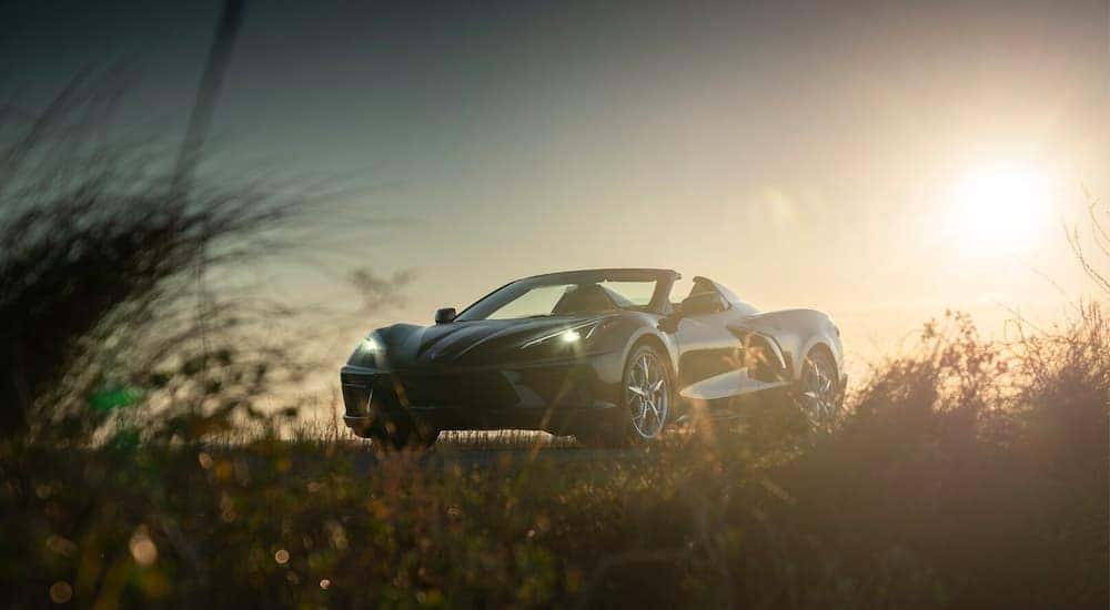 A grey 2021 Chevy Corvette parked in a field on a sunny day.