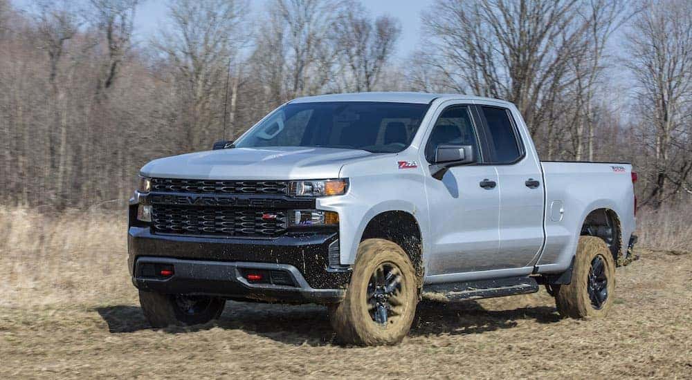 A silver 2020 Chevy Silverado 1500 TrailBoss kicks up mud while off-roading