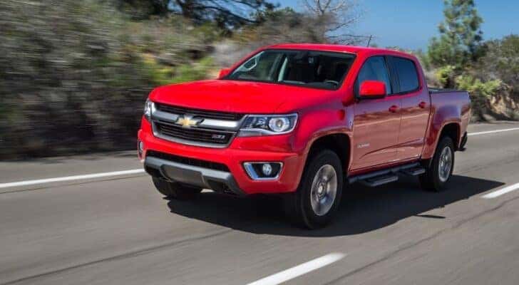 A red 2015 Chevy Colorado is shown from the front at an angle after leaving a used Chevy dealer.