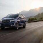 A blue 2022 Chevy Equinox driving on a mountain road
