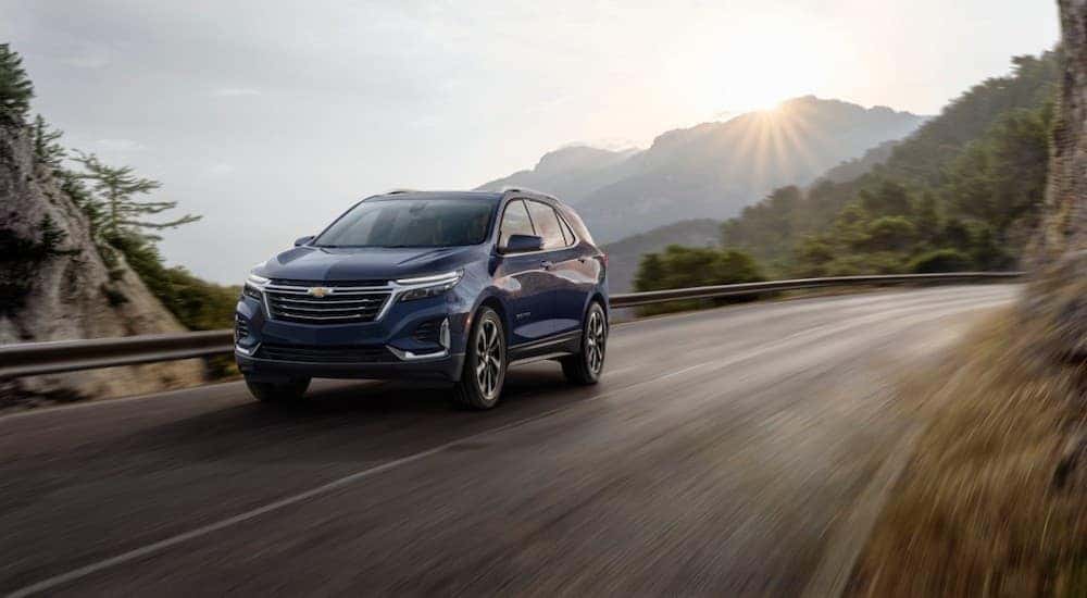 A blue 2022 Chevy Equinox driving on a mountain road