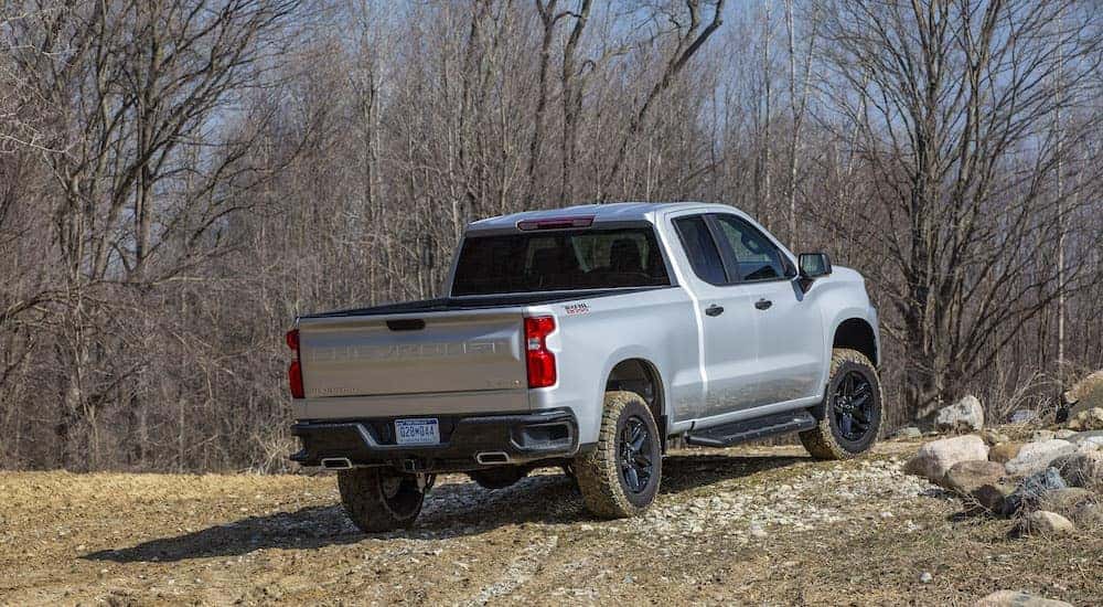 A gray 2022 Chevy Silverado Trail Boss off-roading up a rocky hill