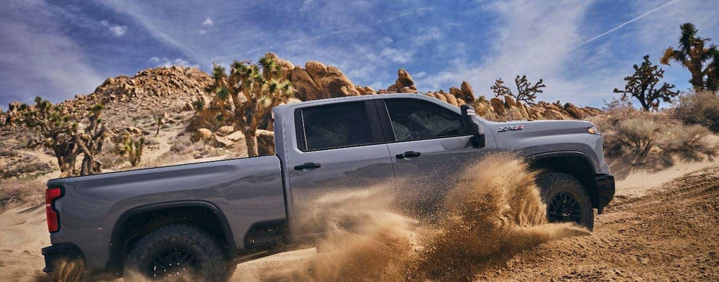 A grey 2024 Chevy Silverado 2500 HD ZR2 is shown off-roading after leaving a Chevy Silverado 2500 dealer.