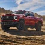 A red 2024 Chevy Silverado 1500 HD ZR2 Bison is shown parked off-road after visiting a truck dealer near Hopkinsville.