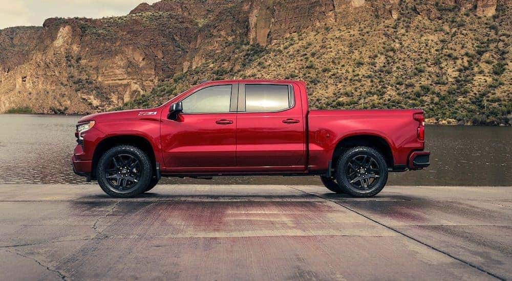 A red 2024 Chevy Silverado 1500 Z71 is shown parked near a lake.