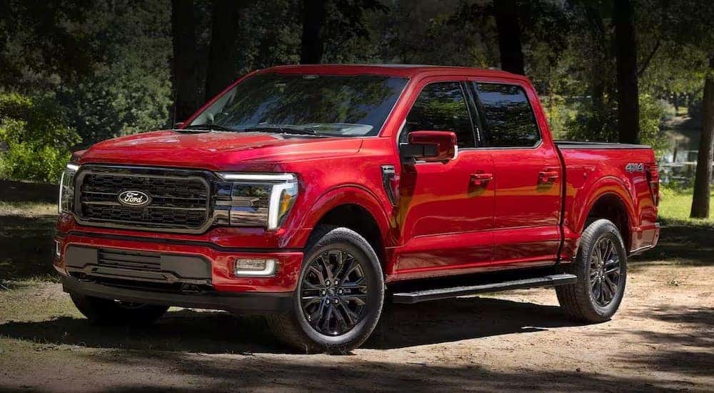 A red 2024 Ford F-150 XLT is shown parked off-road.