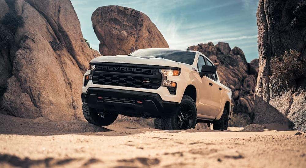 A white 2024 Chevy Silverado 1500 Trail Boss is shown from the front at an angle.