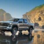 A silver 2024 Chevy Colorado Z71 off-roading through shallow water.