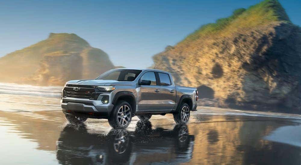 A silver 2024 Chevy Colorado Z71 off-roading through shallow water.