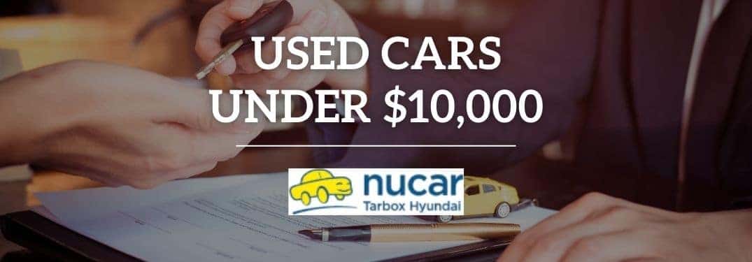 Car Salesman and Buyer Exchanging Keys with White Text and Nucar Hyundai of North Kingstown Logo