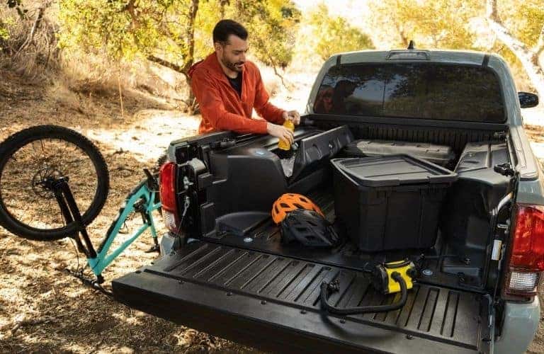 Man Loading Cargo in Rear of 2022 Toyota Tacoma
