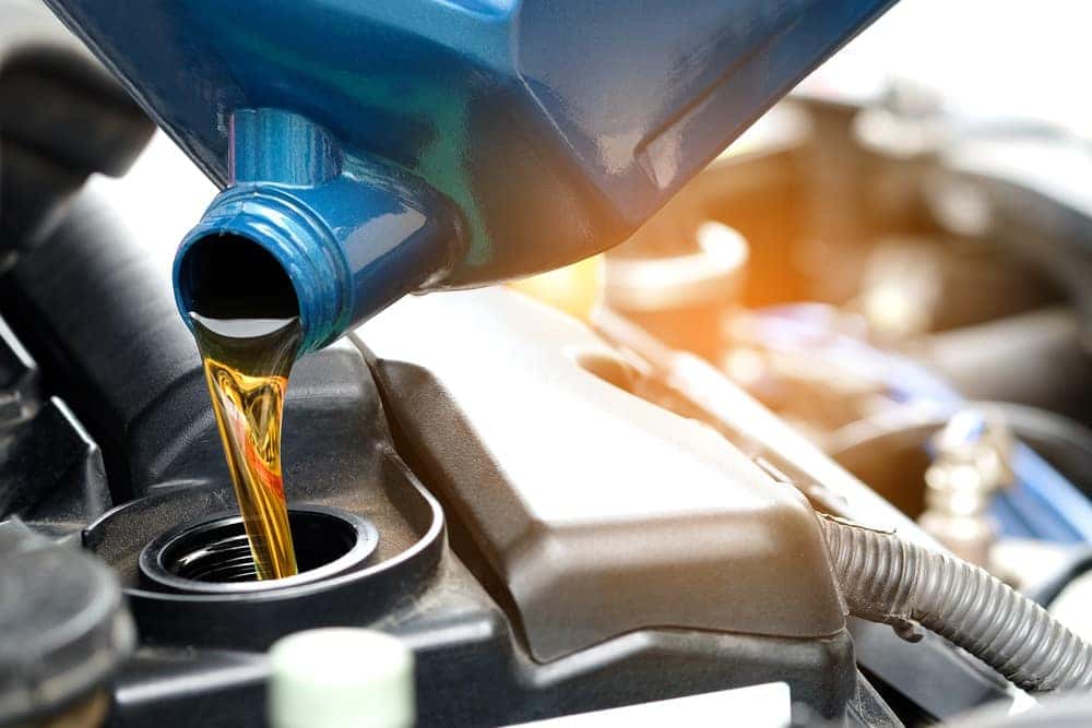 Technician Pouring new Oil into Vehicle at Service Center near Kenner LA