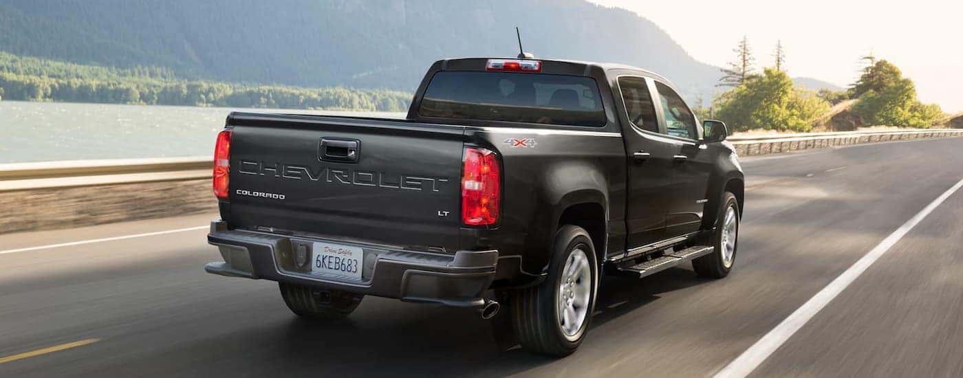 A black 2022 Chevy Colorado LT is shown from a rear angle driving on a highway.
