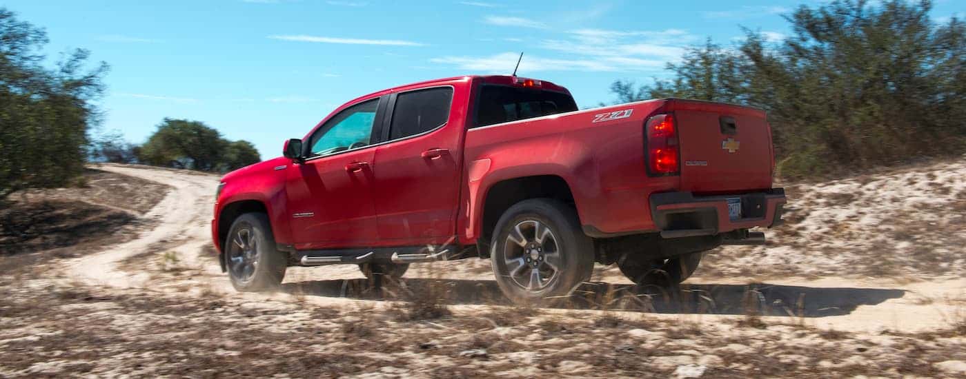 A red 2017 Chevy Colorado Z71 is shown from the side on a dirt path.