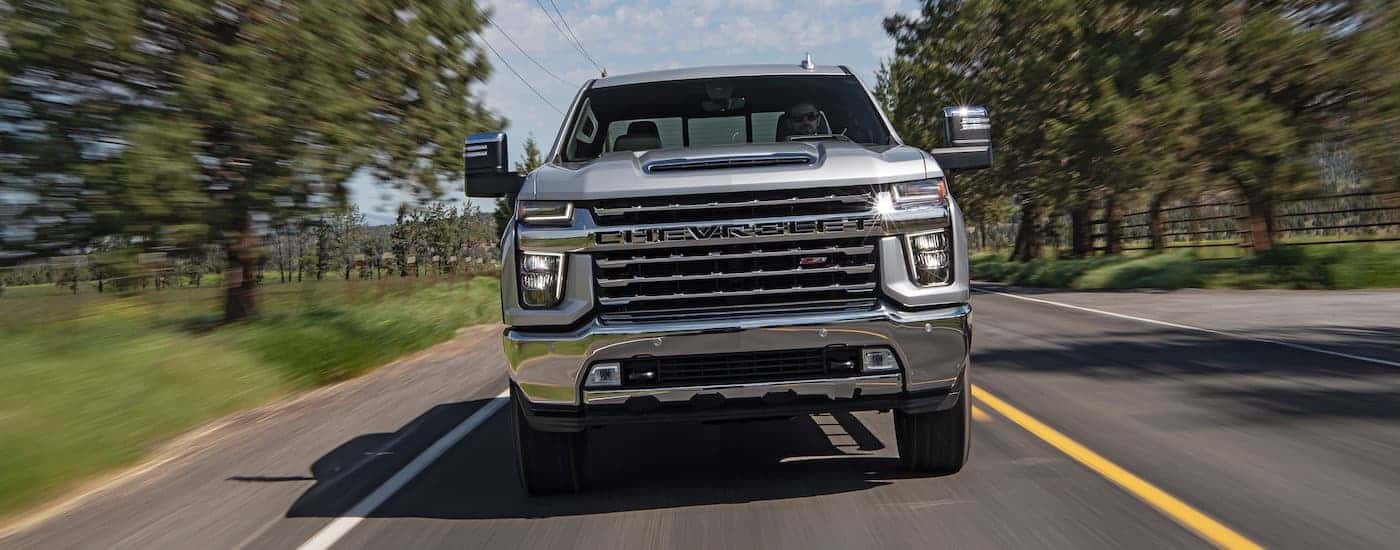 A silver 2020 Chevy Silverado 2500 HD Z71 is shown from the front driving on an open road.