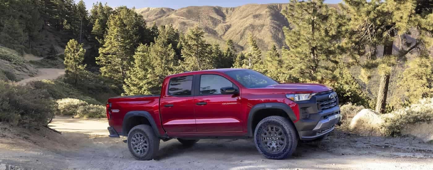 A red 2023 Chevy Colorado Trail Boss is shown from the side while off-road.