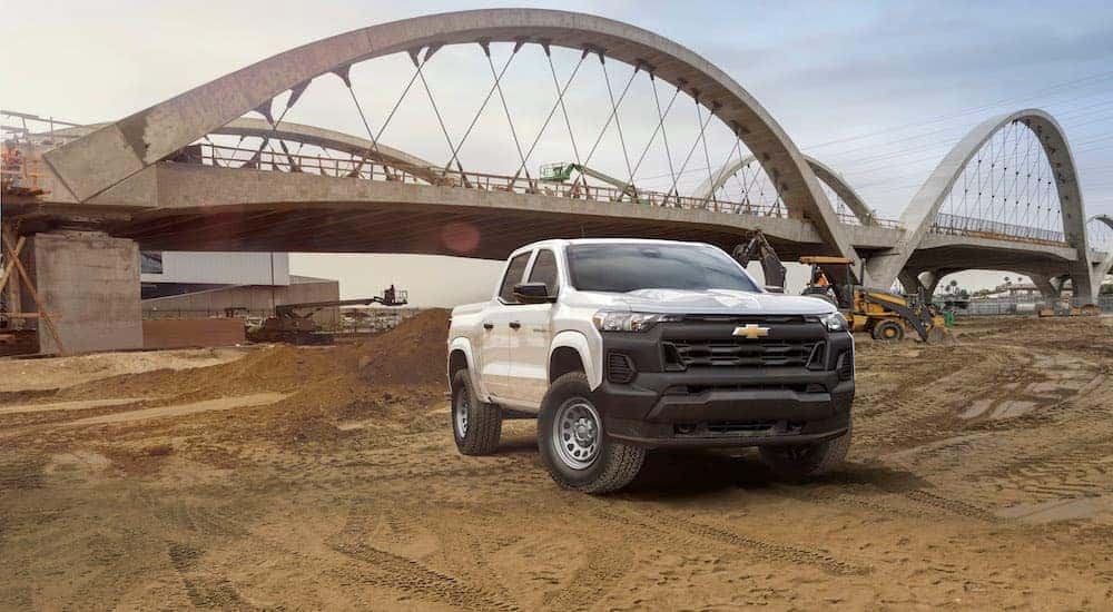 A white 2023 Chevy Colorado WT is shown from the front on a job-site after leaving a dealer that has Chevy trucks for sale in Millbrook.