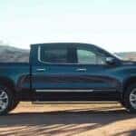 A popular Chevy Silverado 1500 for sale, a black 2024 Chevy Silverado 1500 High Country, is shown parked on a dirt road.