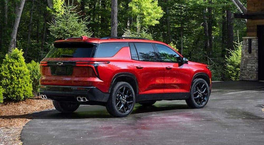 A red 2024 Chevy Traverse RS is shown from the rear at an angle.