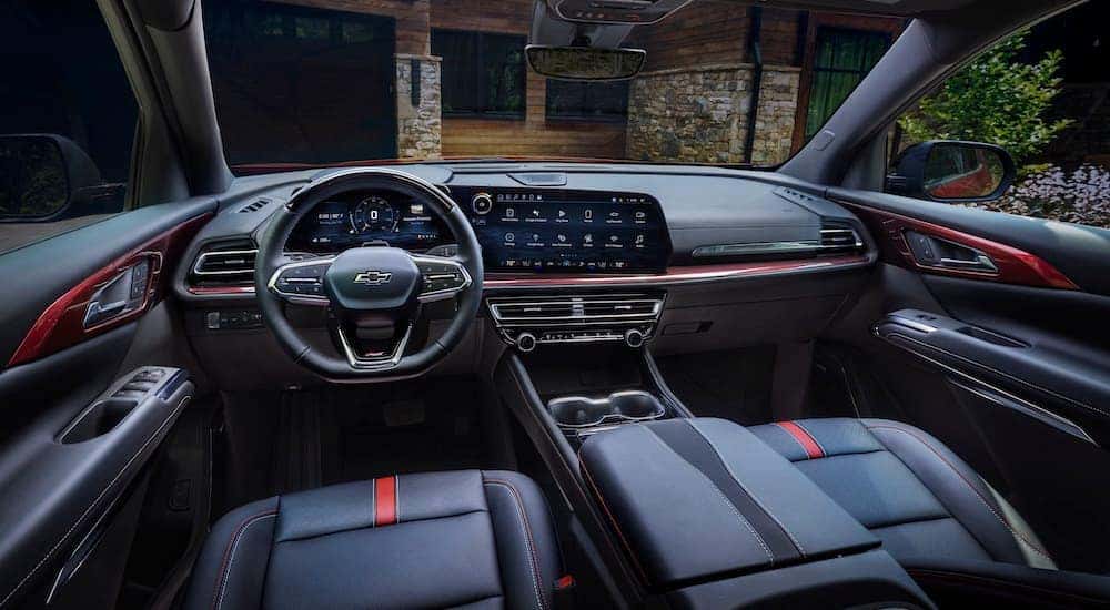 The black and red interior of a 2024 Chevy Traverse RS is shown from the driver's seat.